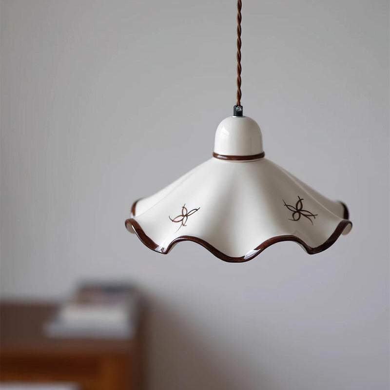 Suspension en céramique blanche ORÉA plissée, vue en situation, lumière allumée – Ambiance Éclat